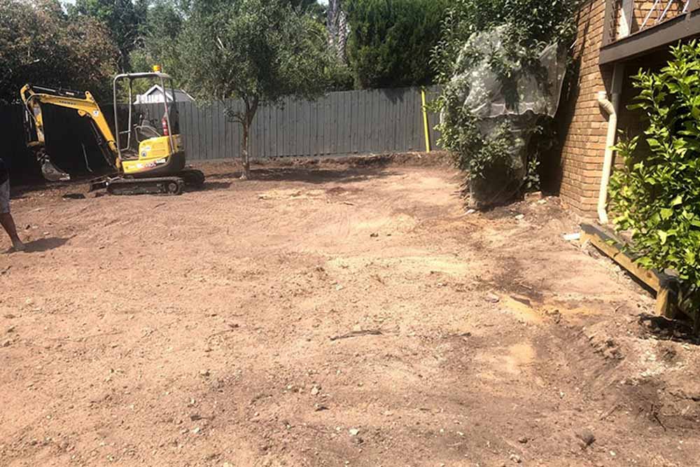 Mini excavator leveling a backyard